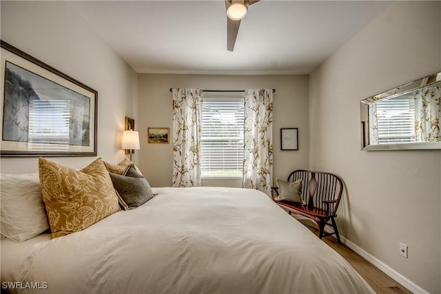 bedroom with wood finished floors, baseboards, and ceiling fan