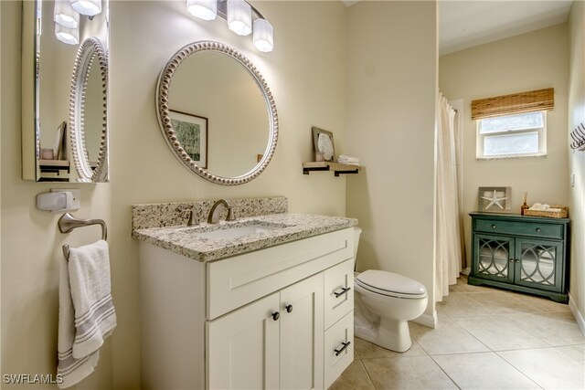 bathroom featuring tile patterned floors, vanity, and toilet