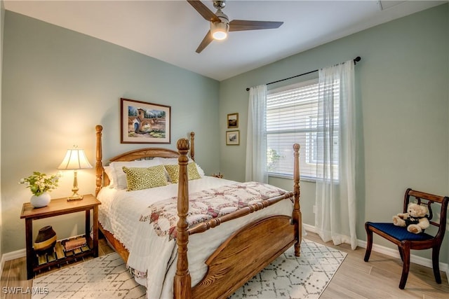 bedroom with wood finished floors, a ceiling fan, and baseboards