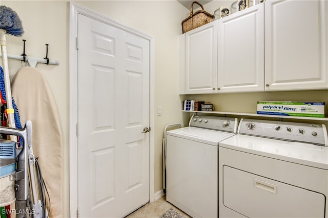 clothes washing area with washer and clothes dryer and cabinets