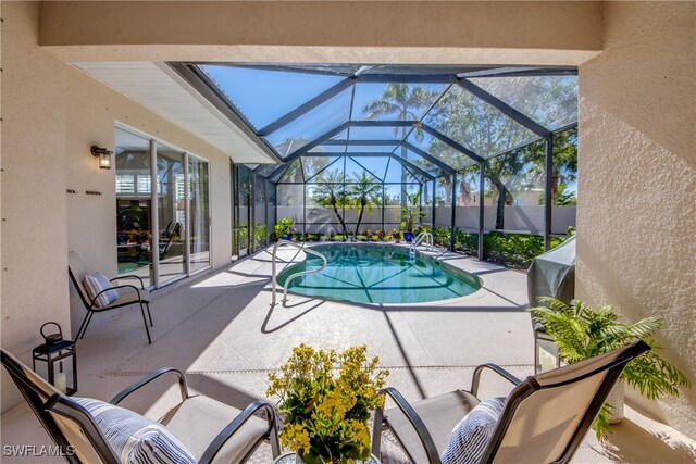 view of swimming pool featuring a lanai and a patio