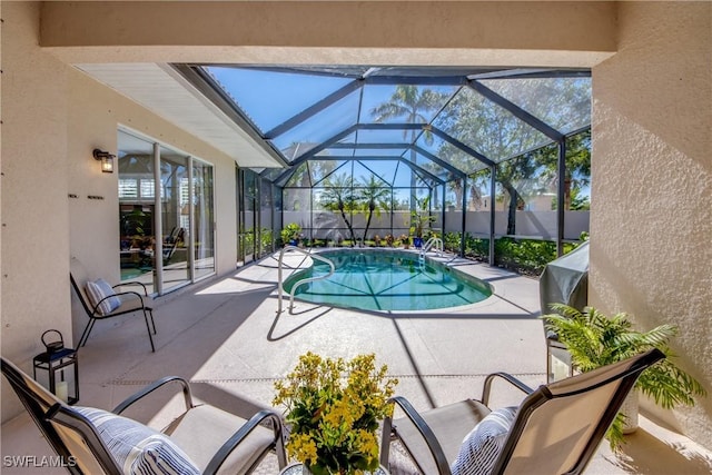 view of pool featuring fence, a patio area, a fenced in pool, and glass enclosure