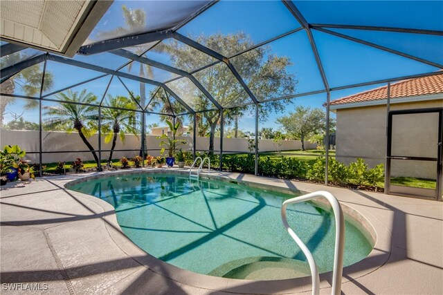 view of swimming pool with glass enclosure and a patio area