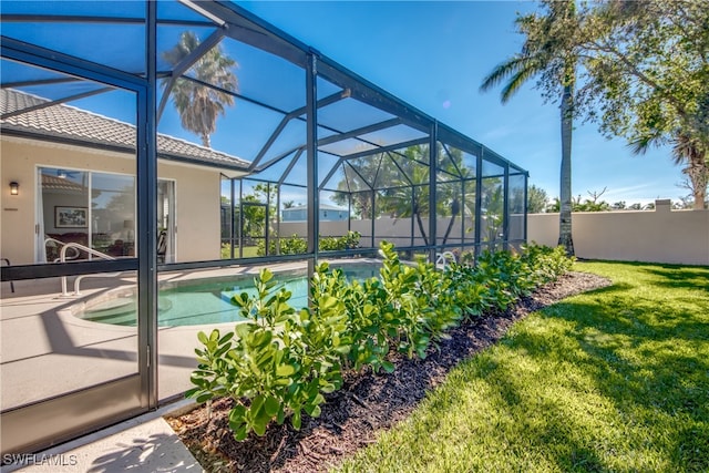 view of pool featuring glass enclosure and a lawn