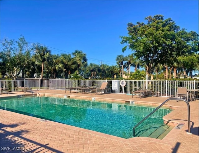 pool featuring fence and a patio area