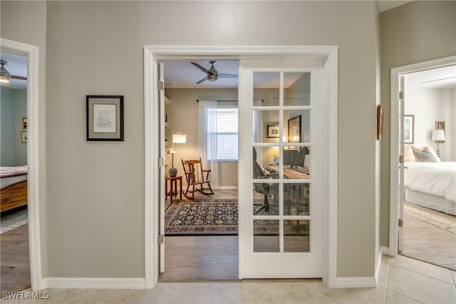 hallway with baseboards and light tile patterned floors
