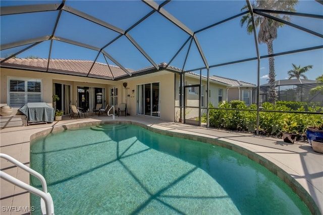 outdoor pool with grilling area, a lanai, and a patio
