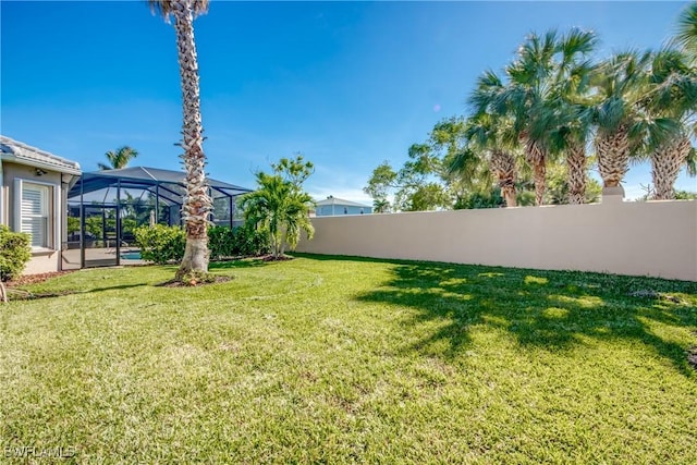 view of yard featuring a fenced backyard and glass enclosure