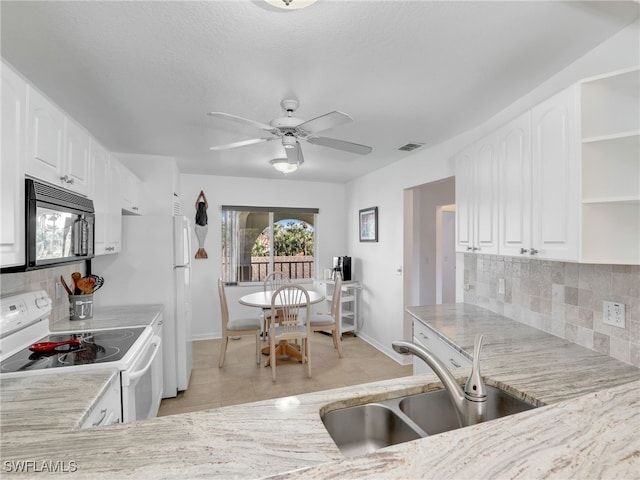 kitchen with white cabinets, white electric range oven, light tile patterned floors, and sink