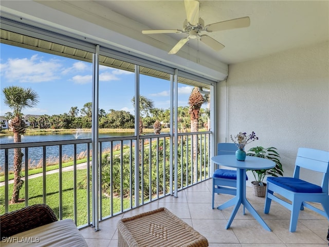 sunroom / solarium featuring a water view and ceiling fan