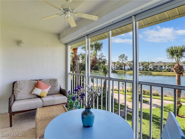 sunroom / solarium with ceiling fan and a water view