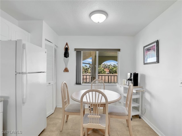 tiled dining area featuring a textured ceiling