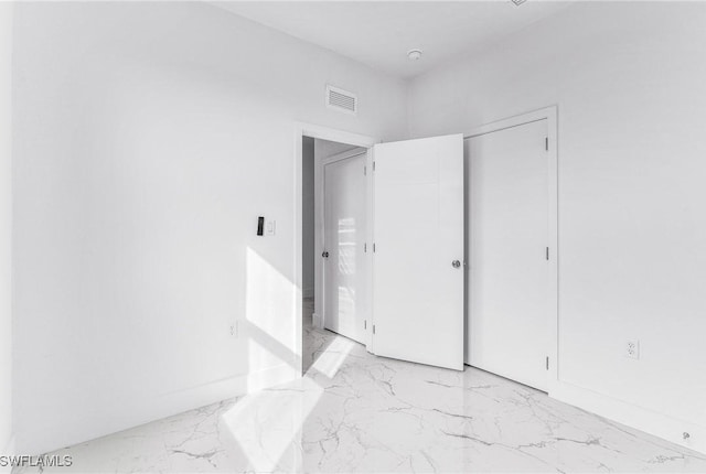 7029 Palpano Cir, Labelle, FL 33935 - unfurnished bedroom with light marble finish flooring, baseboards, and a closet