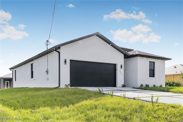 view of front of home featuring a garage and a front lawn