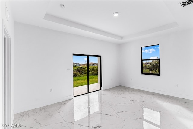 unfurnished room featuring a raised ceiling