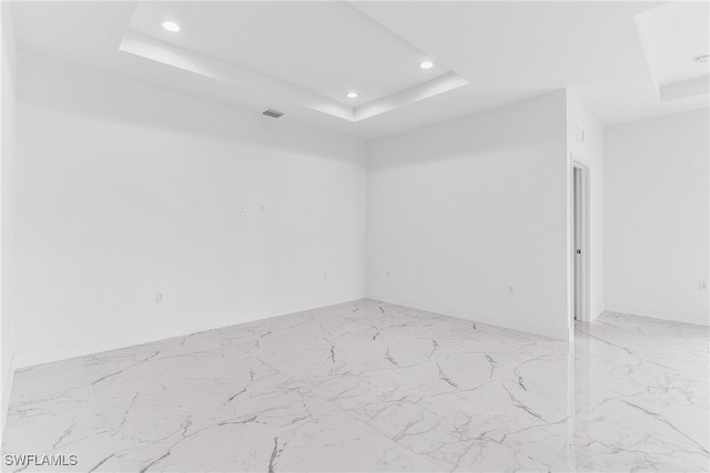 unfurnished room featuring a raised ceiling