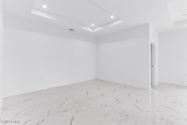 7029 Palpano Cir, Labelle, FL 33935 - spare room featuring a tray ceiling, light marble finish floors, recessed lighting, and baseboards