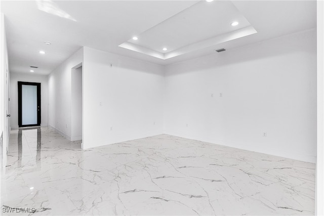 unfurnished room with a tray ceiling