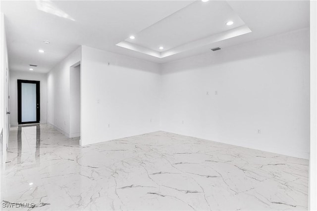 7029 Palpano Cir, Labelle, FL 33935 - empty room with marble tiled floors, recessed lighting, and a raised ceiling