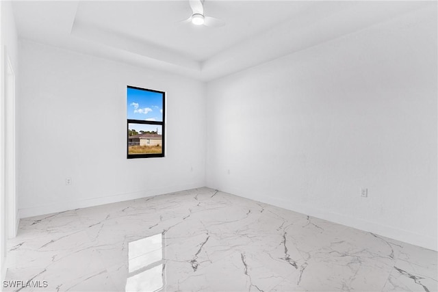 7029 Palpano Cir, Labelle, FL 33935 - spare room featuring marble finish floors, baseboards, a tray ceiling, and ceiling fan