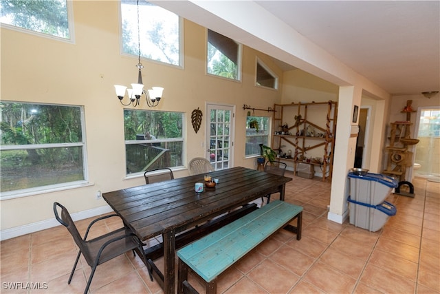 dining room with a chandelier, light tile patterned floors, and high vaulted ceiling