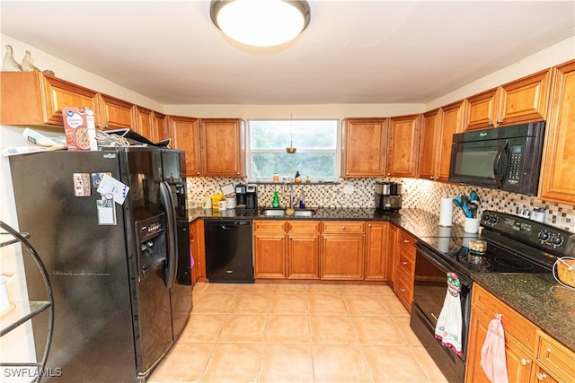 kitchen with backsplash, black appliances, sink, dark stone countertops, and light tile patterned flooring