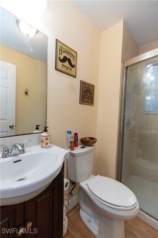 bathroom featuring tile patterned floors, vanity, an enclosed shower, and toilet