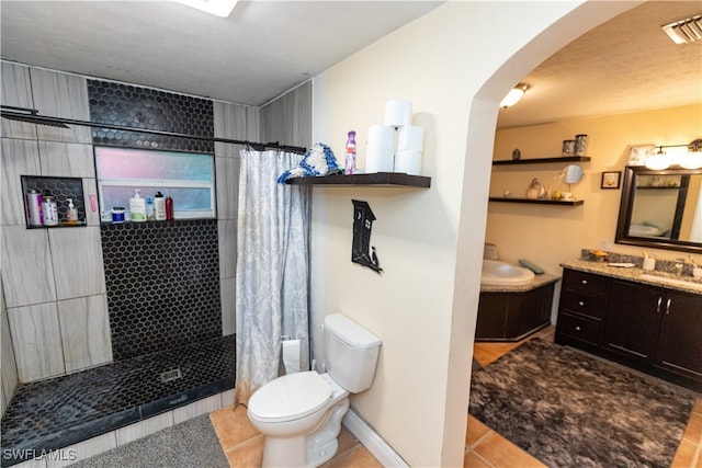 bathroom with toilet, vanity, tile patterned floors, and walk in shower