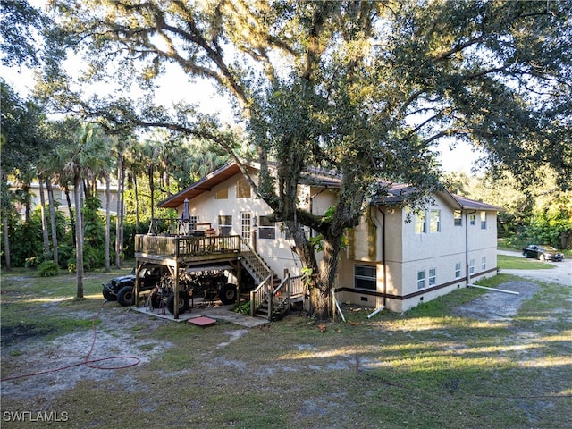 back of property with a deck and a lawn