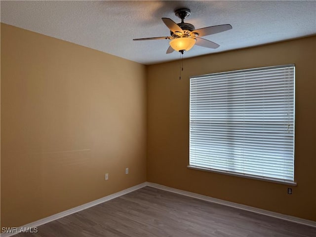 empty room featuring ceiling fan, hardwood / wood-style floors, and a textured ceiling