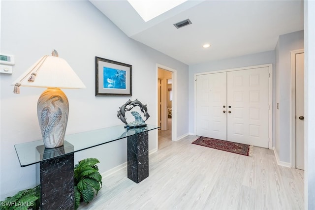 entryway with light hardwood / wood-style floors and a skylight