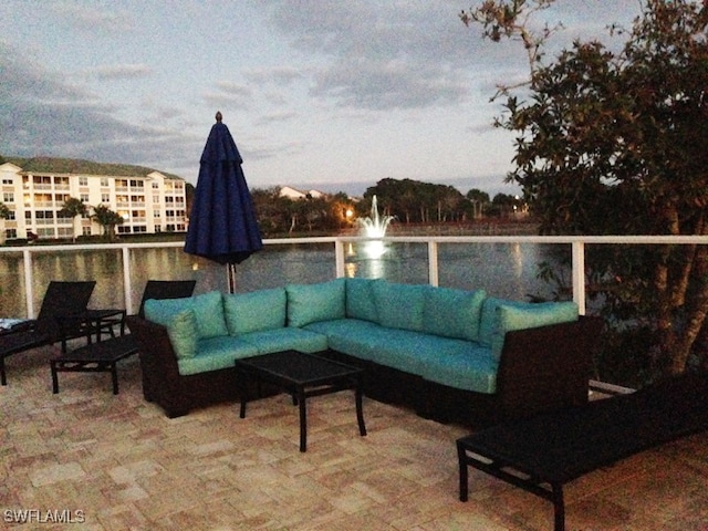 patio terrace at dusk with an outdoor living space and a balcony