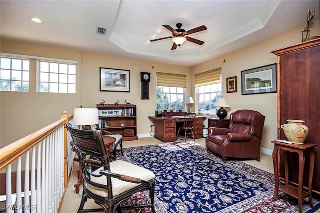 carpeted home office with a tray ceiling, ceiling fan, and crown molding