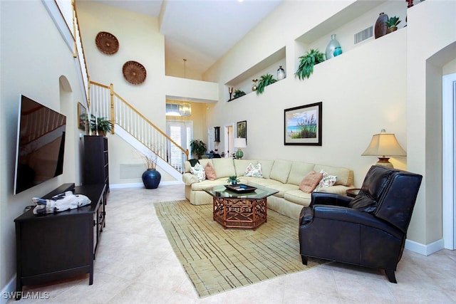 living room with a towering ceiling and an inviting chandelier