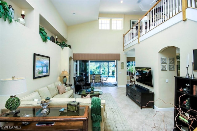 tiled living room featuring a towering ceiling and a wealth of natural light