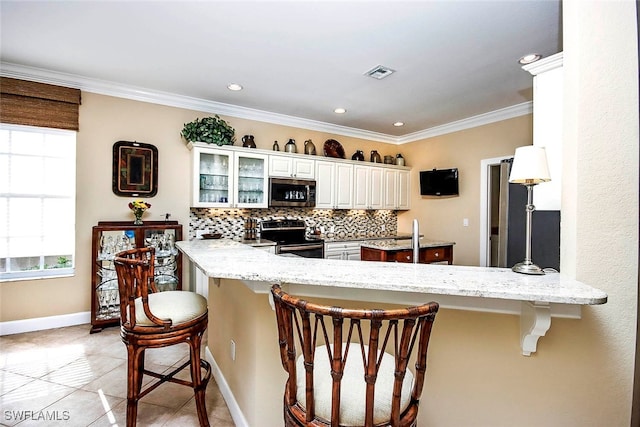 kitchen with a breakfast bar, crown molding, appliances with stainless steel finishes, tasteful backsplash, and kitchen peninsula