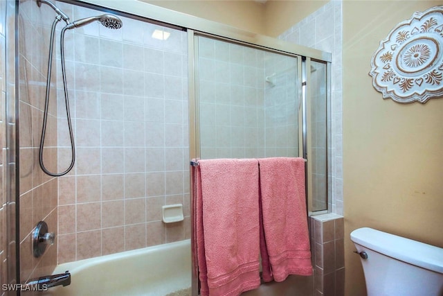 bathroom featuring tiled shower / bath combo and toilet