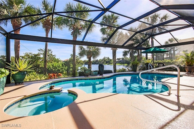 view of pool with glass enclosure, an in ground hot tub, a patio area, and a water view