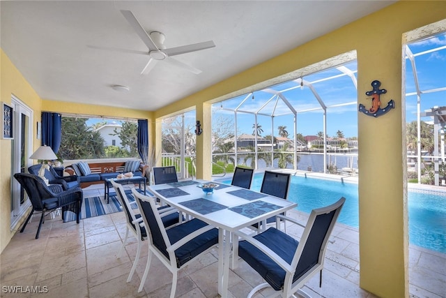 view of patio featuring a water view, glass enclosure, and ceiling fan