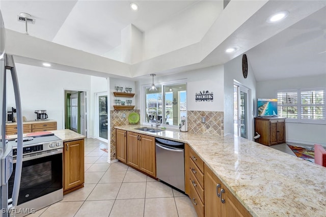 kitchen featuring light stone countertops, appliances with stainless steel finishes, decorative backsplash, and sink