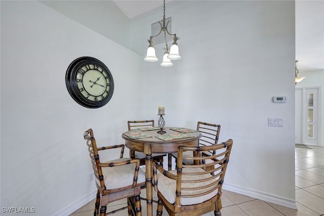 tiled dining space featuring vaulted ceiling and a chandelier