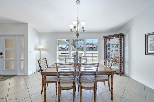 tiled dining room featuring an inviting chandelier