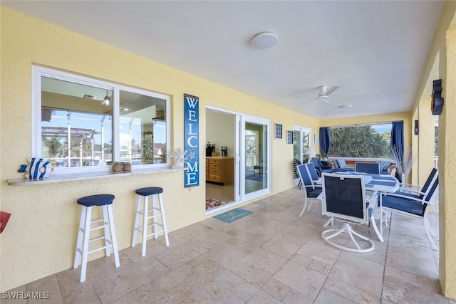 view of patio / terrace featuring ceiling fan and a bar