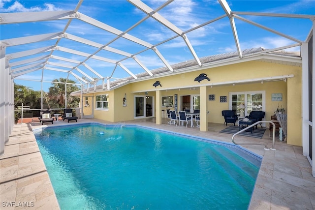 view of pool featuring glass enclosure and a patio