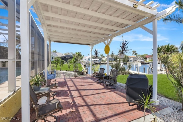 view of patio with grilling area, a water view, and a boat dock