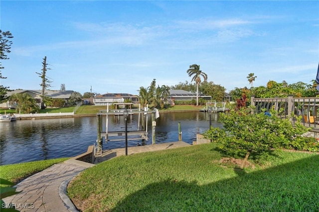 view of dock with a yard and a water view