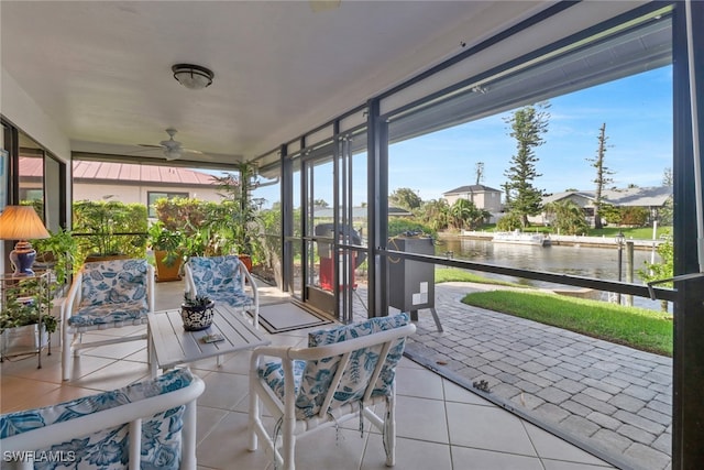 sunroom / solarium featuring a water view, a wealth of natural light, and ceiling fan