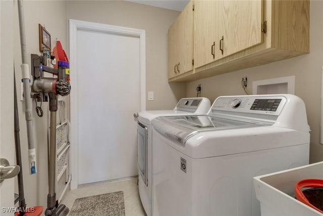 washroom with washer and dryer, light tile patterned flooring, cabinets, and sink