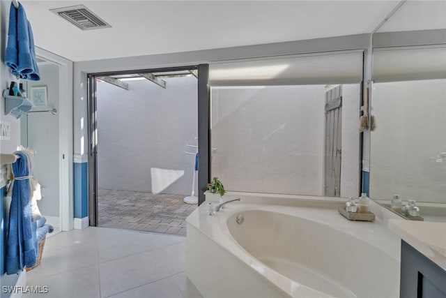 bathroom with vanity, tile patterned floors, and a tub