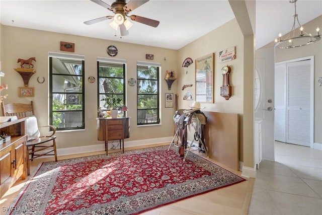 interior space featuring ceiling fan with notable chandelier and light tile patterned flooring